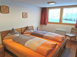 利德阿尔卑斯Chalet Enzian的一间卧室配有两张带枕头的床。