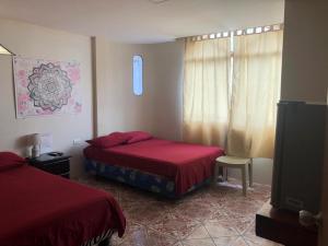 曼塔Hostal Malania的一间卧室配有两张床和一台平面电视