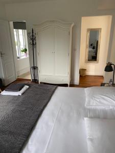 Saint Cyr-sous-DourdanLe Moulin Bleu的一间卧室配有一张大床和一个大型橱柜