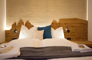 博尔扎诺CityChalet family Bozen的一张配有白色床单和蓝色枕头的大床
