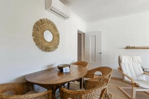 滨海圣西尔Appartement Provenza - Welkeys的一间带木桌和椅子的用餐室
