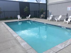 蓝溪市Quality Inn & Suites Blue Springs - Kansas City的一个带椅子和桌子的大型蓝色游泳池