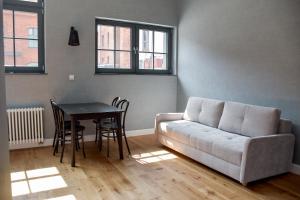 格但斯克Apartamenty Nowy Browar Gdański的客厅配有沙发和桌子