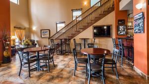 道奇城乡村贝斯特韦斯特PLUS套房酒店的一间酒吧,在楼梯间配有桌椅