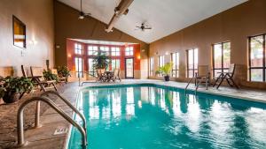 道奇城乡村贝斯特韦斯特PLUS套房酒店的一个带桌椅的房间的游泳池