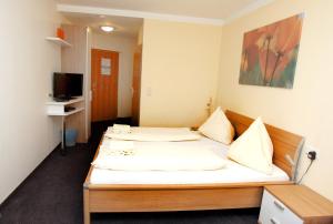 施韦夏特太尼斯韦伯膳食公寓酒店的酒店客房设有两张床和电视。