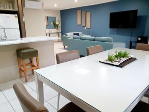 科夫斯港科罗拉湾度假酒店的厨房以及带白色桌椅的起居室。