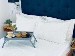 Sere KundaMica Apartments的床上的食品托盘,有白色枕头