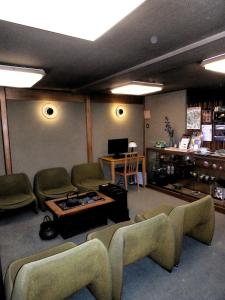 金泽玛拉塔亚酒店的带沙发、桌子和电视的客厅