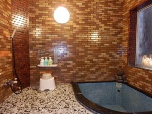 金泽玛拉塔亚酒店的砖墙内带浴缸的浴室