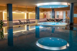 塞格德Hunguest Szeged - ex Forrás的酒店大堂设有游泳池和椅子