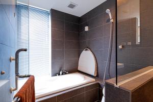 恩纳Onna Beach Square -恩納ビーチスクエア-的设有带浴缸和淋浴的浴室。