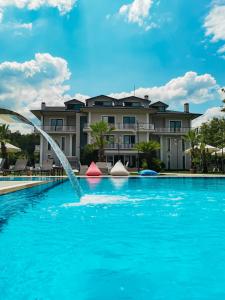 萨潘贾Didi Butik Hotel的一座建筑前的游泳池,喷泉