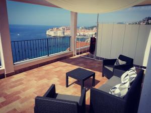 杜布罗夫尼克拉谷萨别墅酒店的阳台配有桌椅,享有海景。