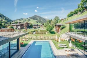 萨尔巴赫Rosentalerhof Hotel & Appartements的享有带游泳池和山脉的房屋景致