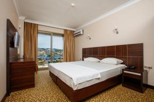 切什梅Suena hotel Çeşme的酒店客房,配有床和电视