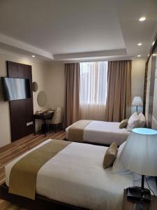 亚的斯亚贝巴Goha Addis Hotel的酒店客房配有两张床和一张书桌