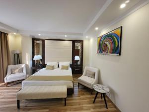亚的斯亚贝巴Goha Addis Hotel的一间卧室配有一张大床和两把椅子