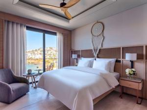 亚力卡瓦克MGallery The Bodrum Hotel Yalikavak的一间卧室设有一张大床和一个大窗户