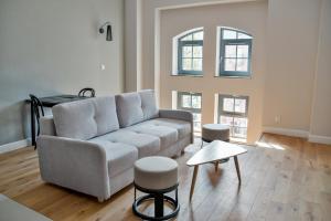 格但斯克Apartamenty Nowy Browar Gdański的客厅配有沙发和桌子