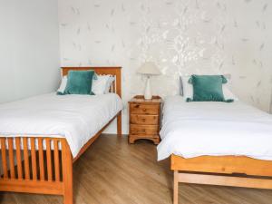 杰德堡Castlebrae的带床头柜的客房内的两张单人床