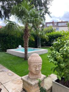 代德斯海姆Apartment am Weinberg的花园内头部雕像,带游泳池