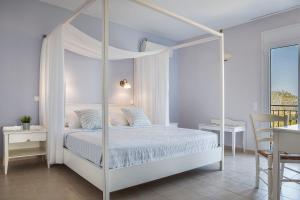 斯沃伦塔ASTRA Village Resort的白色卧室内的白色天蓬床