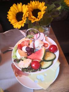 纽哈灵吉塞尔Hotel garni Haus am Meer的花瓶旁边的桌子上放着一盘食物