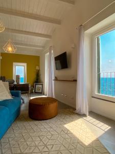 韦尔纳扎La Ripa Camere Vernazza的客厅设有蓝色的沙发和大窗户