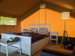 PromultiGlempings Jēru Klubs的一间卧室配有一张橙色墙壁的床