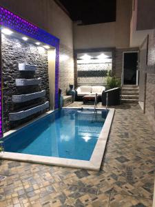 丹吉尔Apartment Nazaha for families only的带沙发的起居室中的大型游泳池