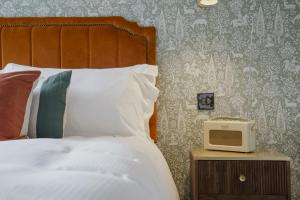 法纳姆贝尔和龙奇德宾馆的一间卧室配有一张床,床头柜上配有一台小电视