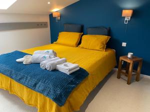 GrazacLe Dôme et son jacuzzi的一间卧室配有黄色的床和毛巾