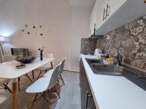 奥林匹亚达Cosy and modern appartment in Olympiada的厨房配有水槽和桌椅