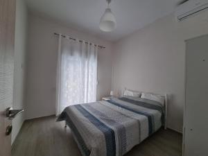 奥林匹亚达Cosy and modern appartment in Olympiada的白色的卧室设有床和窗户