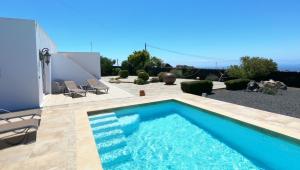 蒂亚斯Villa Essence - a unique detached villa with heated private pool, hottub, gardens, patios and stunning views!的一座房子后院的游泳池