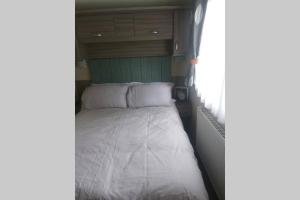古德瑞同Hoburne Devon Bay Static 3 Bed的拖车后面的一张床铺