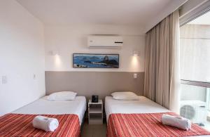 马卡埃Flat 905 - Localização privilegiada em Macaé的酒店客房设有两张床和窗户。