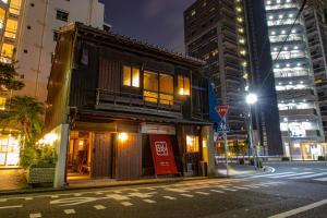 福冈Machiya Villa Seian - Vacation STAY 11749的夜幕在城市街道边的建筑物