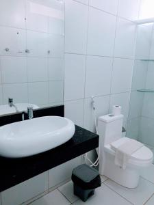 若昂佩索阿Pousada Tambaú的白色的浴室设有水槽和卫生间。