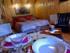 埃特勒塔La Cabane de Cécile-la Hutte的一间卧室配有床和一张带盘子及玻璃杯的桌子
