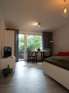 林道Claar Ferienwohnung Lindau Bodensee的一间卧室配有一张床和一张桌子及一台电视