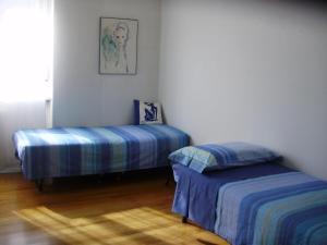 特伦托Bed and Breakfast Relax的一间卧室设有两张床,墙上挂着一幅画