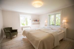 Kungsberga丽拉索加登旅馆的一间卧室配有一张床和一把椅子,还有两个窗户