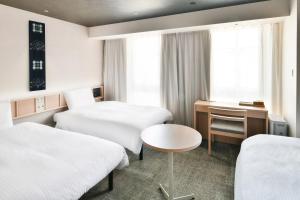 松山REF Matsuyama City Station by VESSEL HOTELS的酒店客房配有两张床和一张书桌