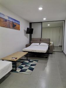 巴兰基亚Berilo Deluxe Apartahotel的一间设有两张床和一张桌子的房间