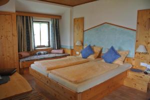 米尔施塔特纽鲍尔乡间别墅住宿加早餐旅馆的一间卧室配有一张带蓝色枕头的大床