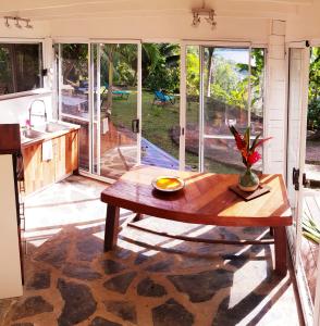 HaapuManta Lodge avec 4x4 Pleine nature的厨房以及带木桌的起居室。