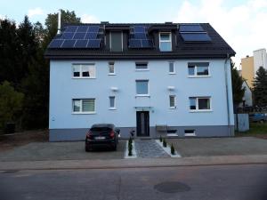 WellesweilerSarah klein aber fein的屋顶上设有太阳能电池板的白色房子