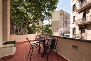 巴塞罗那Decô Apartments Barcelona-Born St.的阳台的天井配有2把椅子和1张桌子